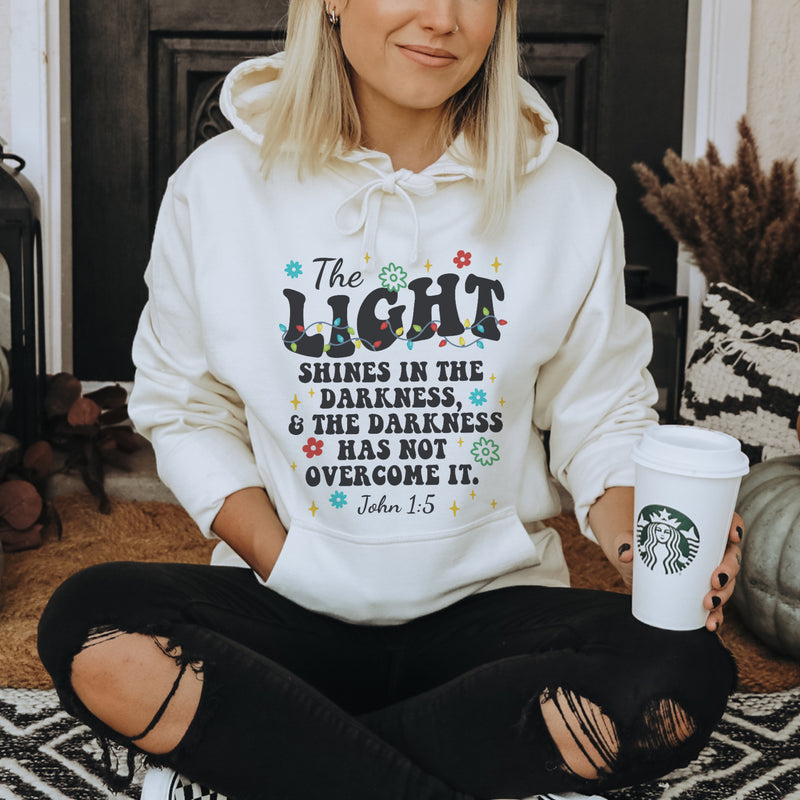The light shines in the darkness hoodie